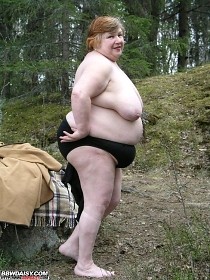A mature fattie getting undressed in the middle of the forest